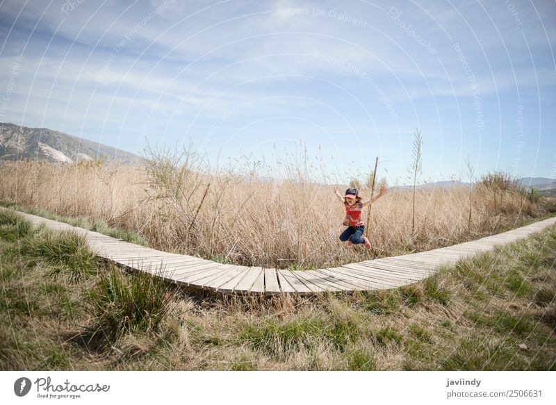 Little girl jumping on a path of wooden boards in a wetland Lifestyle Joy Happy Beautiful Leisure and hobbies Summer Child Girl Infancy 1 Human being