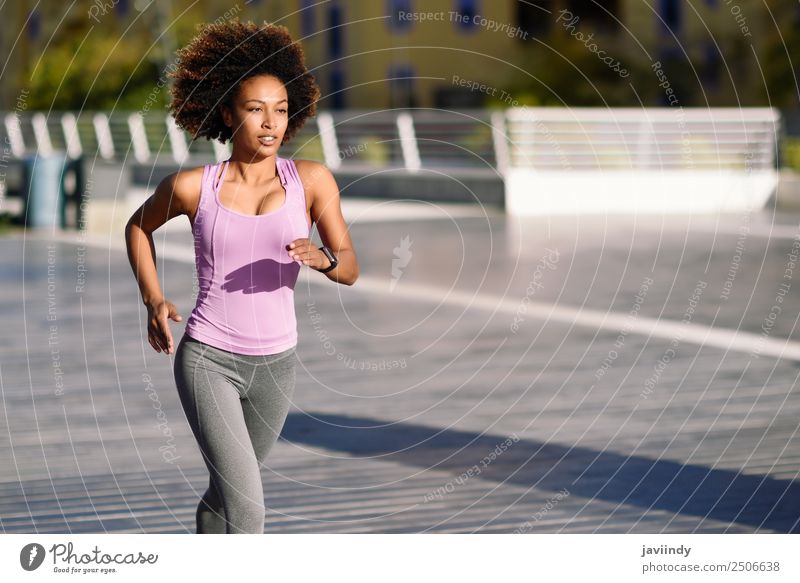 Black woman afro hairstyle running outdoors in urban road Lifestyle Beautiful Hair and hairstyles Wellness Leisure and hobbies Sports Jogging Human being