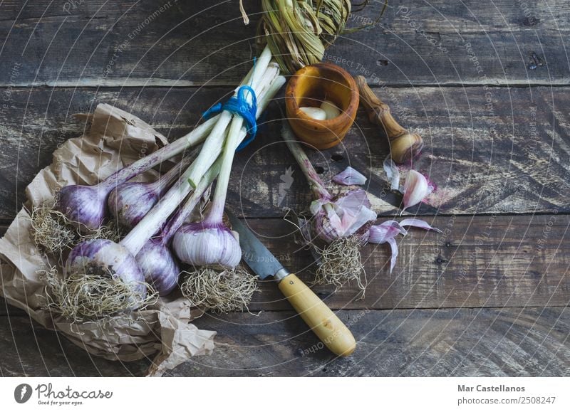 Bunch of garlic with kitchenware on wooden background Vegetable Herbs and spices Nutrition Eating Organic produce Knives Kitchen Nature Plant Summer