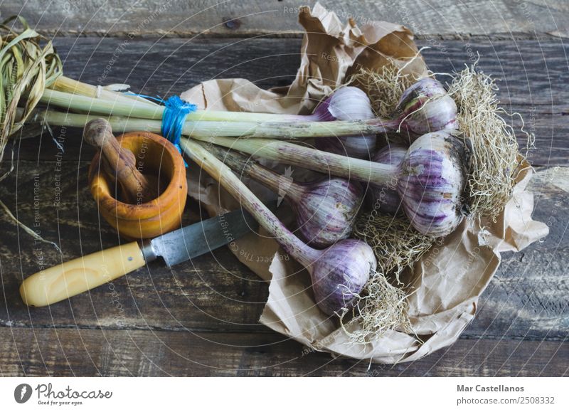 Bunch of garlic with kitchenware on wooden background Vegetable Herbs and spices Nutrition Eating Knives Kitchen Nature Plant Summer Leaf Agricultural crop Wood