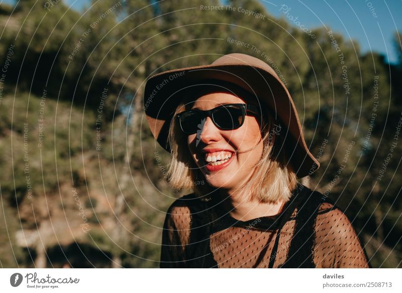 Portrait of blonde woman with hat and sunglasses having fun in nature at sunset. Lifestyle Style Joy Beautiful Wellness Well-being Vacation & Travel Freedom