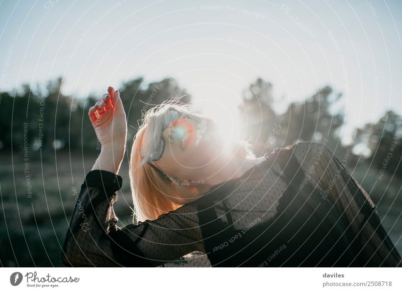 Cool blonde woman performing dancing at sunset and raising the hand close to her head Lifestyle Elegant Style Joy Beautiful Harmonious Sun Feminine Young woman