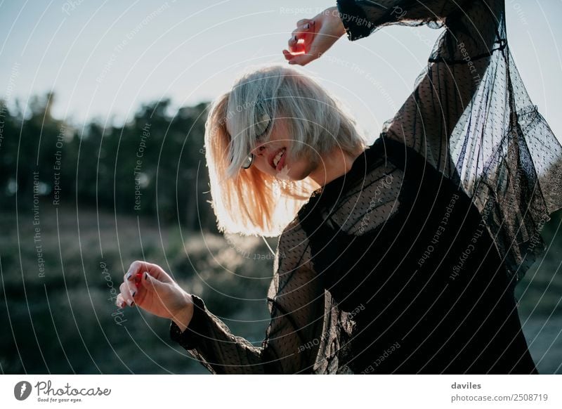 Blonde woman with black dress performing dance at sunset. Lifestyle Elegant Style Joy Beautiful Sun Human being Feminine Young woman Youth (Young adults) Woman
