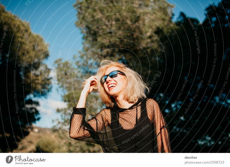 Cool blonde woman with sunglasses and black dress having fun in nature during sunset. Lifestyle Elegant Joy Happy Beautiful Wellness Sun Human being Feminine