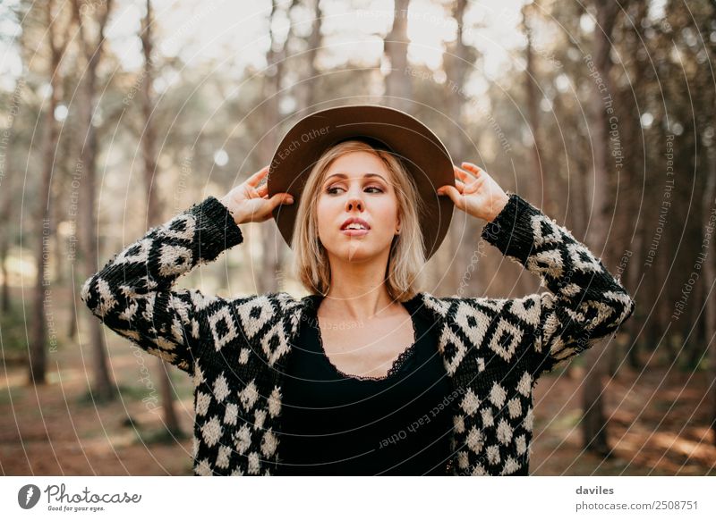 Blonde woman portrait with the hands in her hat, discovering the forest. Lifestyle Elegant Style Beautiful Vacation & Travel Freedom Human being Feminine