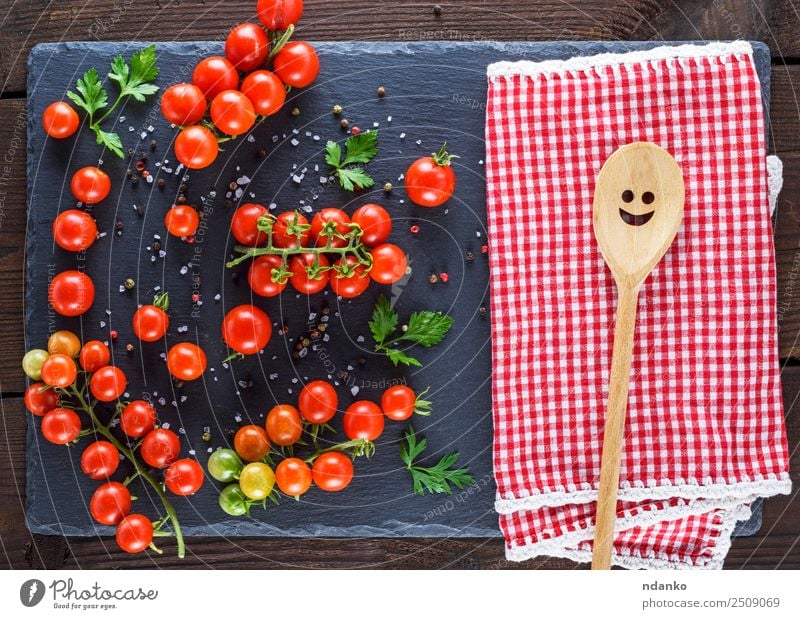 red tomatoes on a black board Vegetable Herbs and spices Nutrition Vegetarian diet Diet Spoon Summer Kitchen Nature Wood Fresh Small Natural Above Juicy Green
