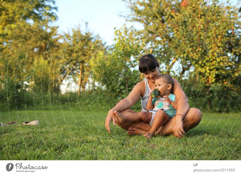 mother holding child eating a cucumber in a beautiful garden Lifestyle Leisure and hobbies Playing Mother's Day Human being Child Baby Young woman