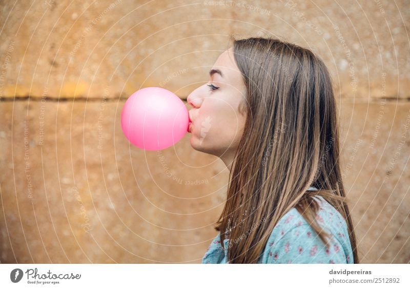 Young teenage girl blowing pink bubble gum over stone wall background Lifestyle Joy Happy Beautiful Face Human being Woman Adults Youth (Young adults) Mouth