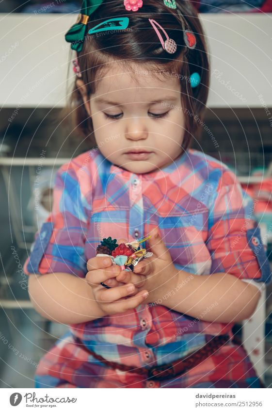 Baby girl playing with hair clips in the hands Lifestyle Joy Happy Beautiful Playing House (Residential Structure) Child Human being Toddler Woman Adults