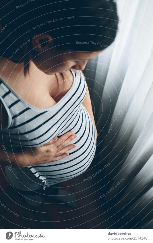 Pregnant woman looking her belly Beautiful Life Parenting Human being Baby Woman Adults Mother Breasts Hand Think Love Wait Authentic Expectation Future tummy
