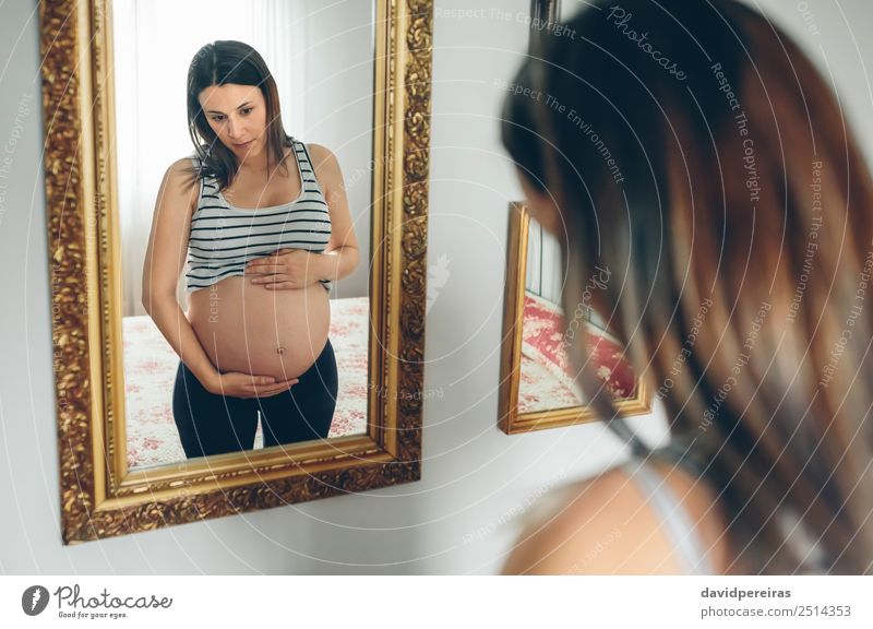 Pregnant woman looking her belly Lifestyle Beautiful Mirror Bedroom Human being Baby Woman Adults Parents Mother Hand Think Growth Wait Authentic Naked Cute
