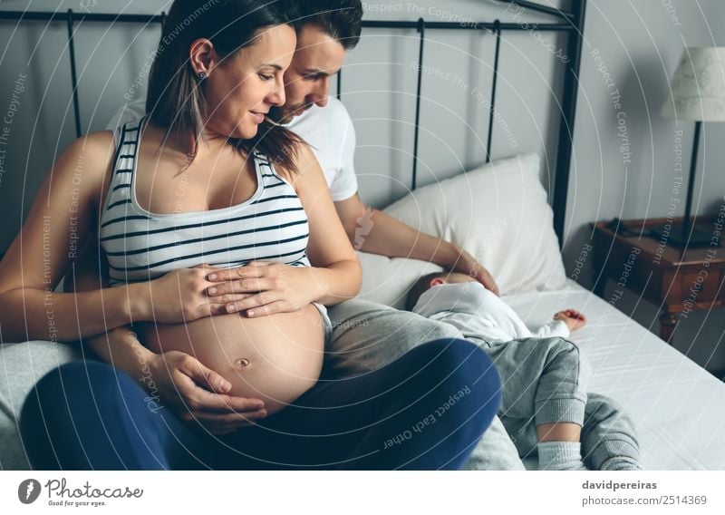 Pregnant woman with husband looking sleeping son Happy Beautiful Relaxation Bedroom Child Human being Baby Toddler Woman Adults Man Parents Mother Father