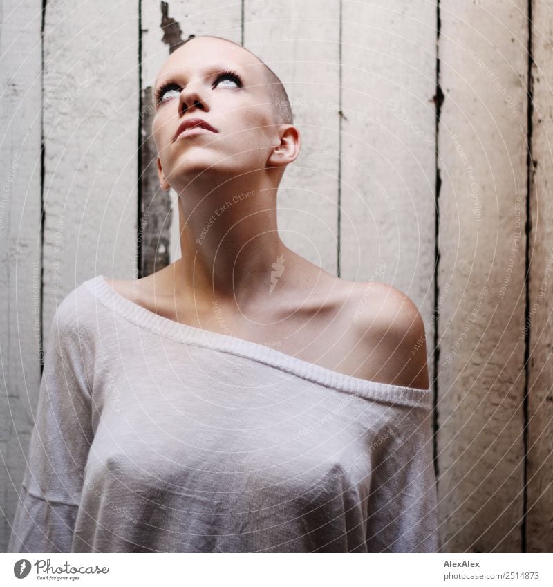 Portrait of a young, very short-haired woman wearing an off-the-shoulder top through which you can see her nipples Style Exotic pretty Calm Young woman