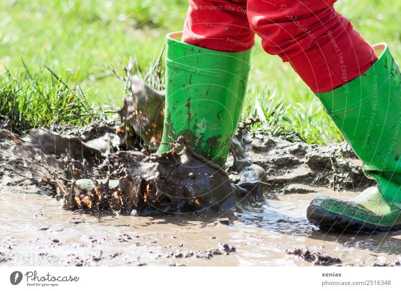 Muddling in the puddle with green rubber boots Joy Child Infancy Legs 1 Human being 3 - 8 years 8 - 13 years Jeans Boots Rubber boots Jump Dirty Brown Red