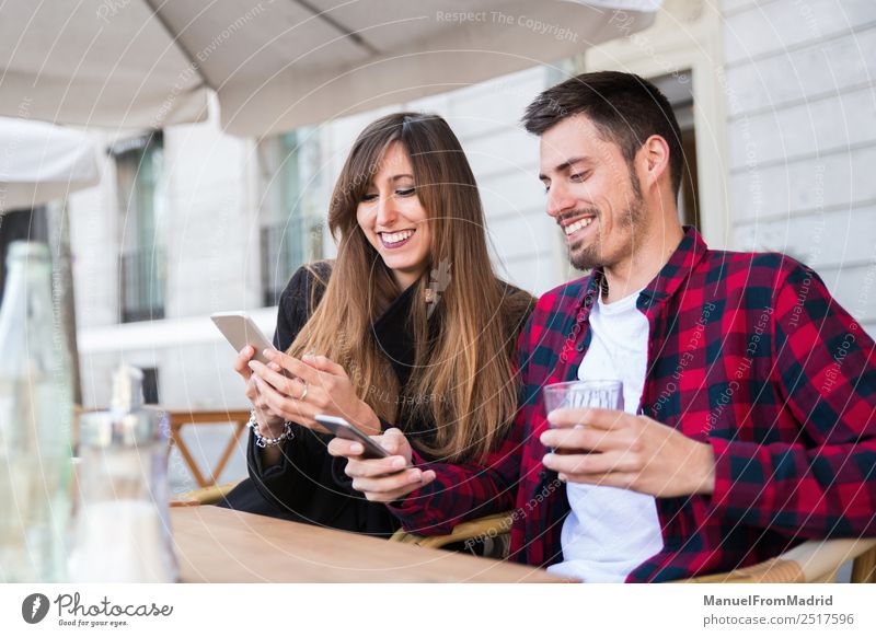 young couple sitting at a terrace Lifestyle Happy Leisure and hobbies Vacation & Travel Table Restaurant Telephone PDA Technology Internet Woman Adults Man