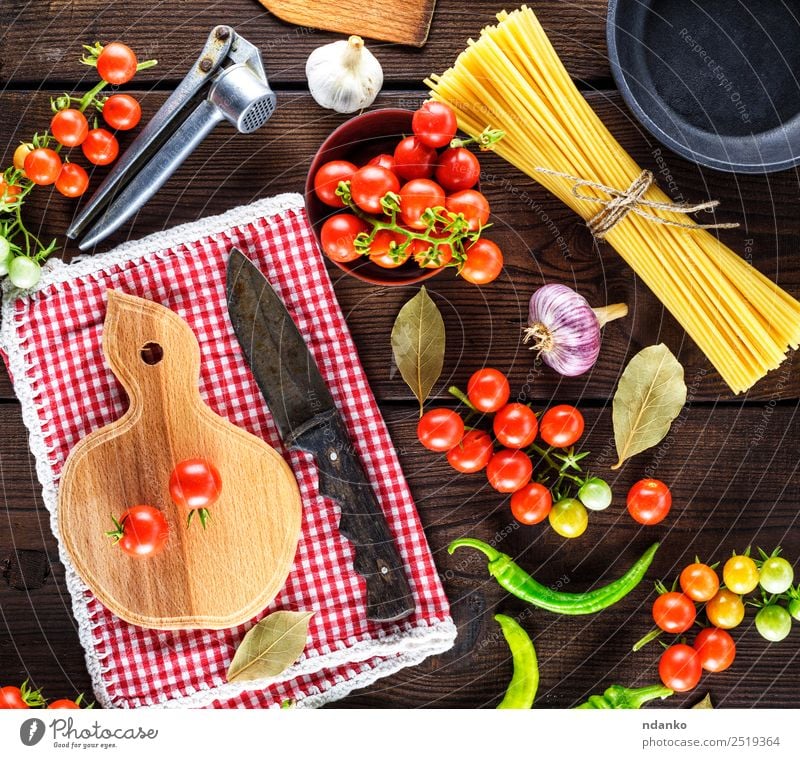red cherry tomatoes and spaghetti Vegetable Dough Baked goods Herbs and spices Lunch Dinner Pan Knives Wood Line Eating Fresh Large Long Above Brown Yellow Red