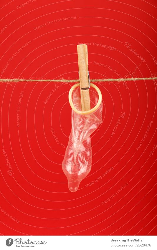 Close up condom on washing line with clothepin Healthy Health care Medication Retro Red Relaxation Disappointment Colour Frustration Sex Sexuality Condom