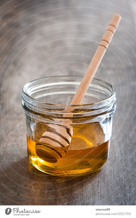 Honey dipper with honey in a jar on wood Food Candy Nutrition Diet Bottle Glass Spoon Healthy Healthy Eating Wood Fluid Sweet Liquid Food photograph Vitamin