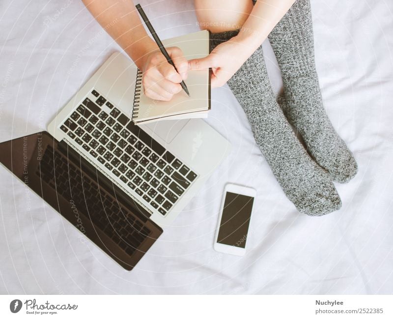 Woman legs in socks and writing on notebook over laptop on bed Lifestyle Shopping Style Winter Bedroom Work and employment Business Telephone PDA Computer
