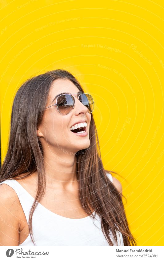 attractive young woman with sunglasses against yellow background Style Joy Happy Beautiful Summer Human being Woman Adults Fashion Sunglasses Smiling Stand