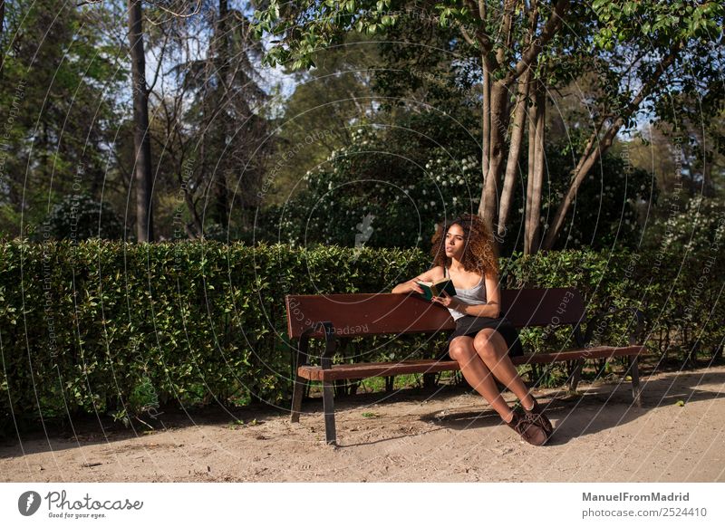 afro woman reading a book on a bench Lifestyle Happy Beautiful Leisure and hobbies Reading Summer School Study Human being Woman Adults Book Nature Tree Grass