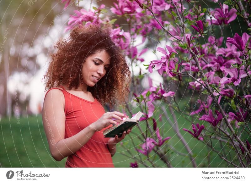 afro woman reading a book outdoors Lifestyle Happy Beautiful Leisure and hobbies Reading Summer Garden School Study Human being Woman Adults Book Nature Tree