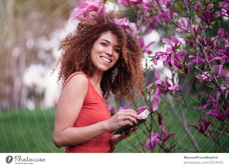 cheerful afro woman holding a book Lifestyle Happy Beautiful Leisure and hobbies Reading Summer Garden School Study Camera Human being Woman Adults Book Nature