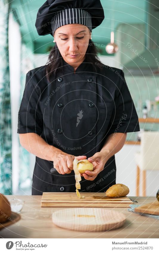 woman chef peeling a potato Nutrition Plate Table Kitchen Human being Woman Adults Hand Wood Modern Concentrate cook potatos Potatoes food Professional knife