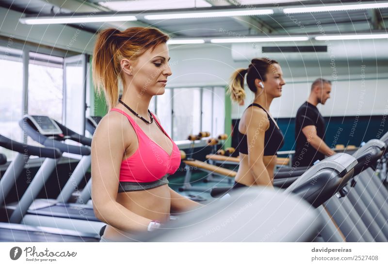 Woman training over treadmill on fitness center - a Royalty Free