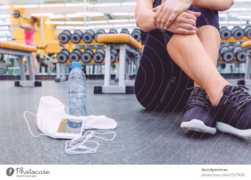 Sporty woman sitting with dumbbells, water and smartphone in gym Bottle Lifestyle Beautiful Body Leisure and hobbies Music Sports Telephone PDA Human being