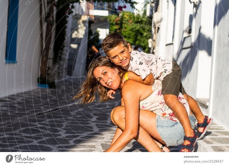 Boy climbed on his mother's back on the street of a Greek village Lifestyle Joy Happy Beautiful Playing Vacation & Travel Tourism Summer Island Child