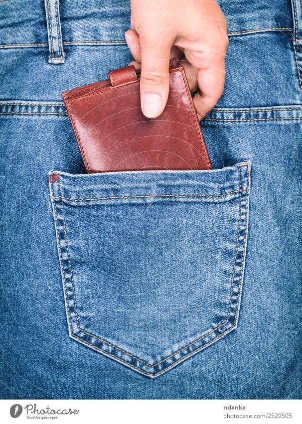 female hand clings to a purse Style Money Business Human being Woman Adults Hand Fashion Clothing Pants Jeans Leather To hold on Blue Brown Crisis Risk Lose