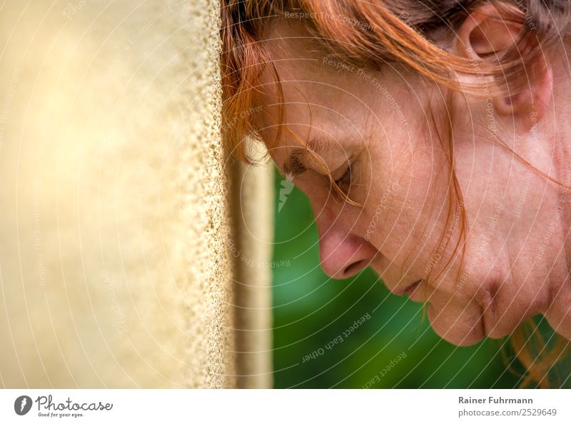 a woman leans her head against a wall Human being Feminine Woman Adults Female senior Head 1 Red-haired Sadness Old Emotions Moody Fatigue Pain Longing