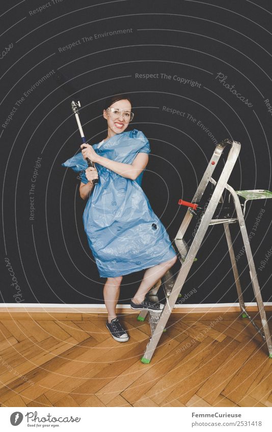 Woman in protective clothes posing with a blue paint roller #DIY Leisure and hobbies Feminine Adults 1 Human being 18 - 30 years Youth (Young adults)