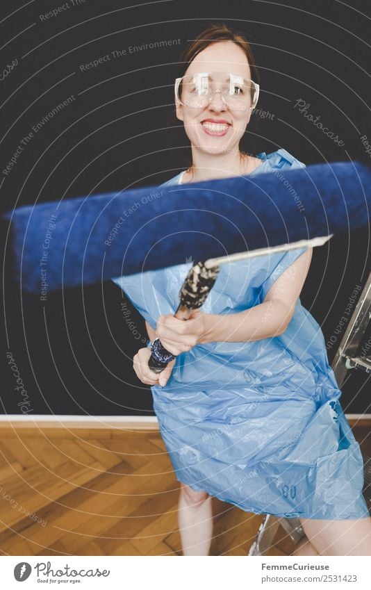 Woman in protective clothes posing with a blue paint roller #DIY Leisure and hobbies Feminine Adults 1 Human being 18 - 30 years Youth (Young adults)