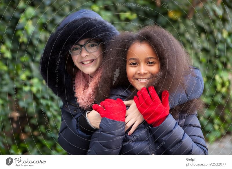 Two happy girls in the park with coats Joy Happy Beautiful Face Winter Child Human being Family & Relations Friendship Infancy Park Coat Scarf Gloves Afro