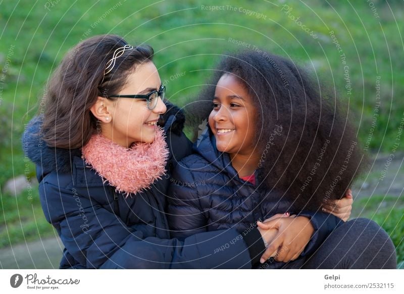 Two happy girls in the park with coats Joy Happy Beautiful Face Winter Child Human being Family & Relations Friendship Infancy Grass Park Coat Scarf Gloves Afro