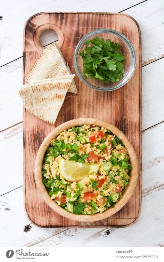 Tabbouleh salad with couscous on white wood. Top view. Table Salad Vegetable Tomato Cucumber Parsley Mint Vegan diet Vegetarian diet Healthy Healthy Eating