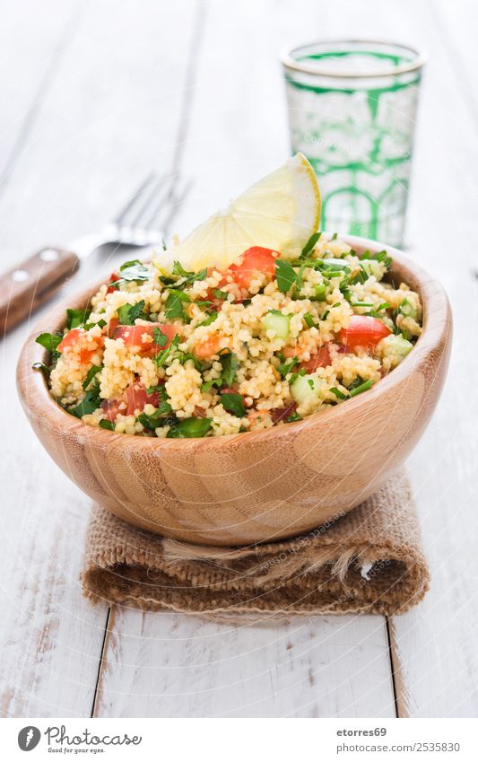Tabbouleh salad with couscous on white wood. Table Salad Vegetable Tomato Cucumber Parsley Mint Vegan diet Vegetarian diet Healthy Healthy Eating Nutrition Diet