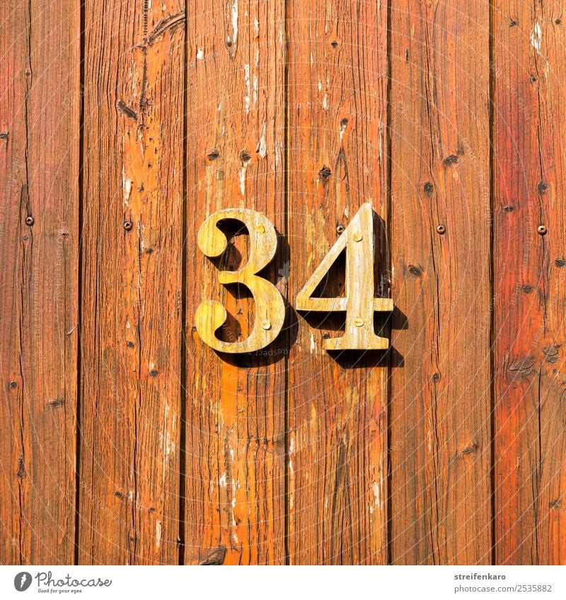 Wooden numbers 34 on one of the wooden slatted doors Flat (apartment) House (Residential Structure) House number Building Digits and numbers Sign Esthetic Brown