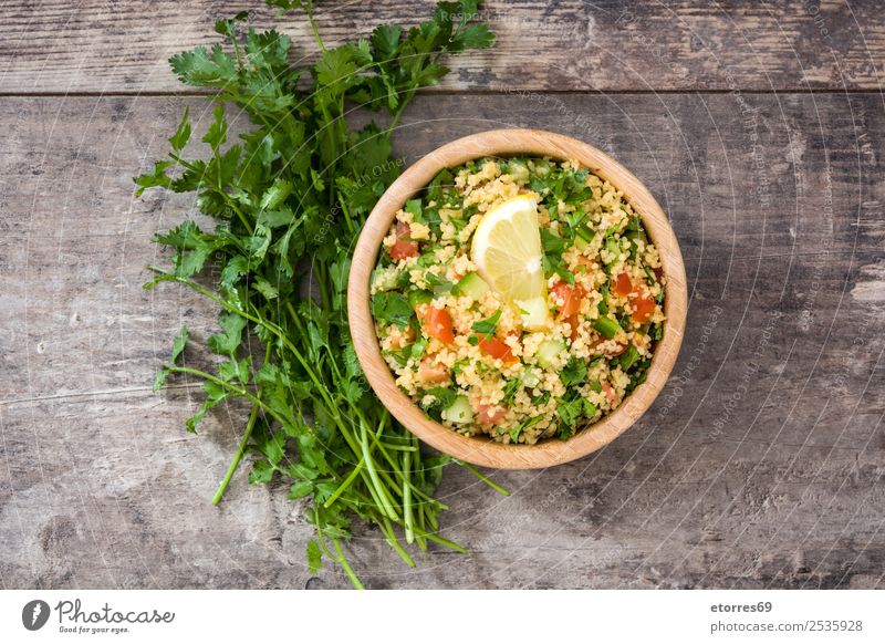 Tabbouleh salad with couscous on a wood. Table Salad Vegetable Tomato Cucumber Parsley Mint Vegan diet Vegetarian diet Healthy Healthy Eating Nutrition Diet