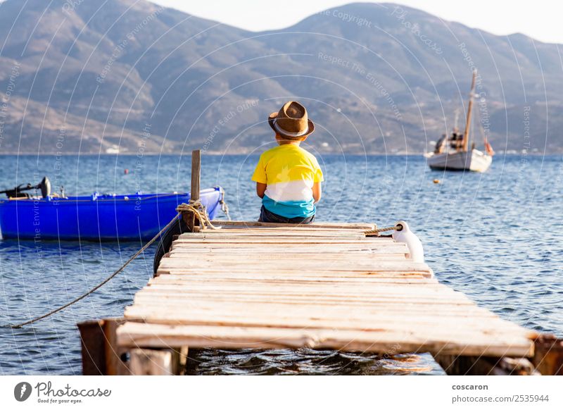 Little boy on a dock sitting on his back looking to the ocean Lifestyle Joy Happy Leisure and hobbies Vacation & Travel Summer Beach Ocean Child Human being