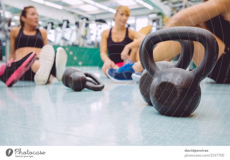 Black iron kettlebell on the floor of fitness center Lifestyle Body Club Disco Sports Woman Adults Man Friendship Group Fitness Authentic Together Muscular