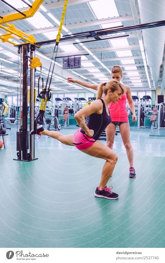 Female Personal Trainer Teaching To Woman In A Hard Suspension Training  With Fitness Straps On A Fitness Center Stock Photo, Picture and Royalty  Free Image. Image 40922665.