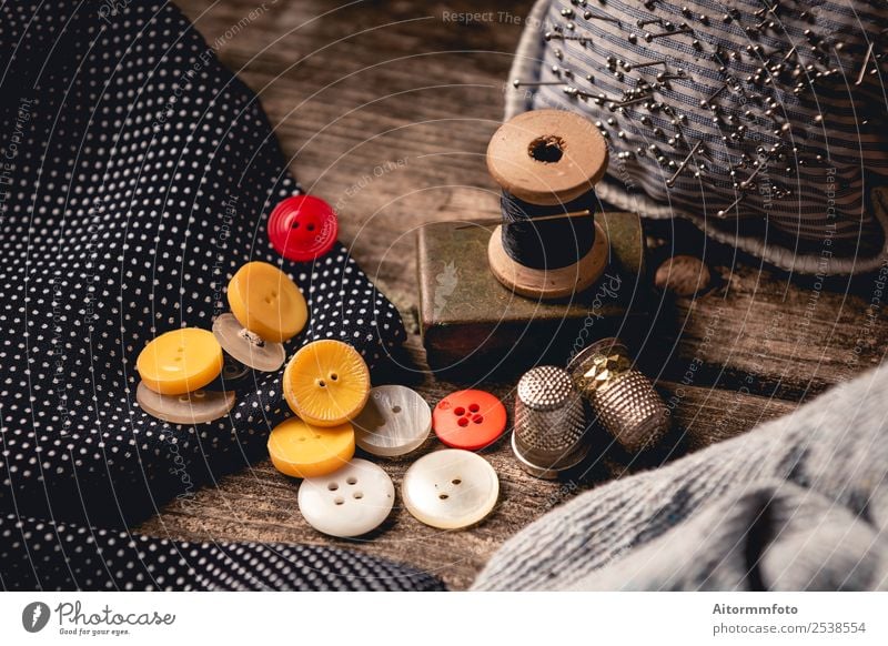 Close-up of wooden sewing spool and buttons set on wooden table Leisure and hobbies Table Workplace Craft (trade) Tool Cloth Accessory Wood Metal Black
