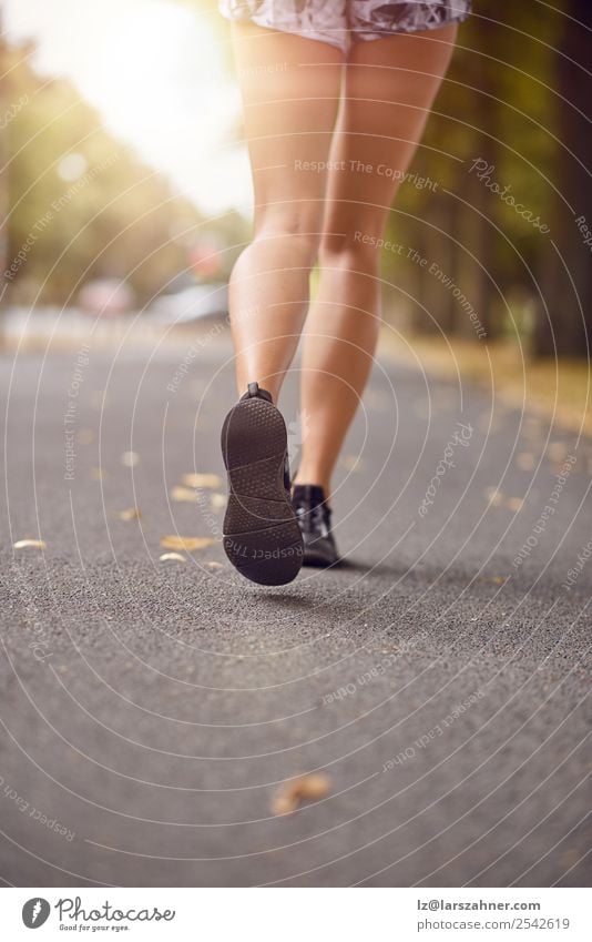 Young woman jogging down an autumn street Lifestyle Relaxation Summer Sun Sports Jogging Human being Woman Adults Feet 1 18 - 30 years Youth (Young adults)