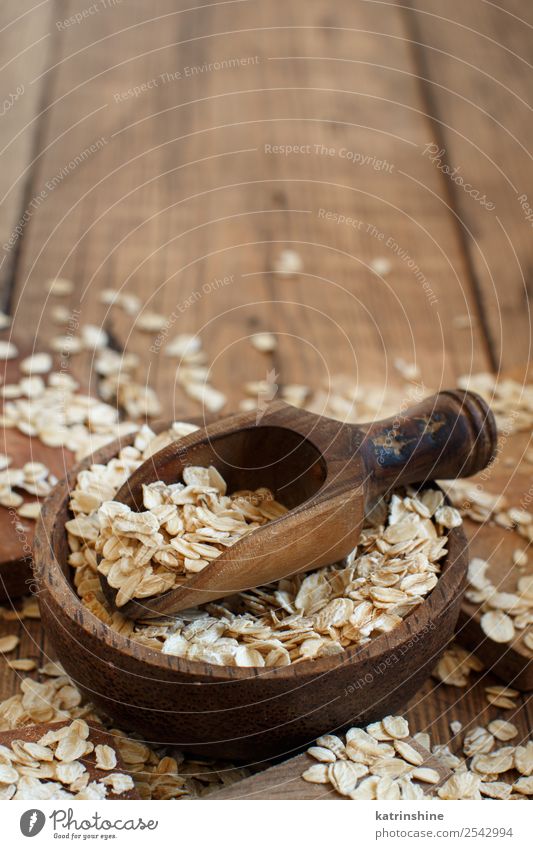 Rolled oats in a bowl with a spoon Nutrition Breakfast Vegetarian diet Diet Bowl Spoon Summer Nature Wood Natural background Cereal Cooking flakes food grain