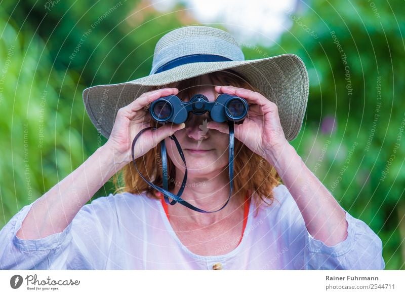 a woman with a hat looks through binoculars Human being Feminine Woman Adults 1 Hat Observe Looking Friendliness Curiosity "Woman Binoculars," Colour photo