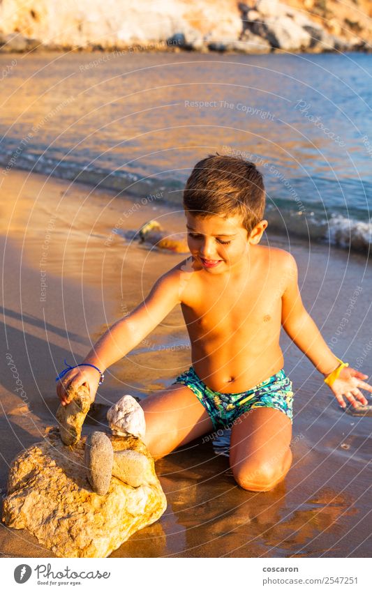 Little kid making constructions with stones on the beach Lifestyle Joy Happy Playing Vacation & Travel Tourism Summer Sun Beach Ocean Child Human being