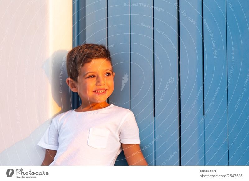 Cute child near of a wooden blue window at sunset Lifestyle Design Happy Beautiful Face Summer House (Residential Structure) Child Human being Baby Toddler